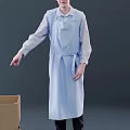 Man Wearing Light Blue Apron And Long Sleeve Shirt Next To Cardboard Box
