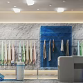 Clothing Store Interior With Gray Stone Wall Blue Panel And Light Colored Garments On Racks