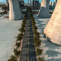 Industrial Plant Exterior Featuring Wide Road Lined With Trees And Tall Concrete Structures