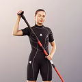 Woman in black wetsuit standing on orange and blue paddleboard holding red and black paddle