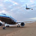 Large Modern Passenger Plane Parked On Sandy Beach During Sunset With Other Aircraft Nearby