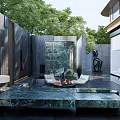 Modern Garden Landscape With Marble Table Fire Pit Seating Stone Wall Sculpture And Lush Greenery