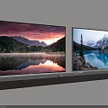 Two Wall Mounted TVs Displaying Natural Scenery of Lakes Mountains and Sunset Reflections