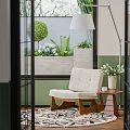 Light Colored Minimalist Single Sofa With Wooden Legs And Side Table In Bright Interior With Green Plants