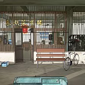 Traditional Storefront with Iron Barred Gate Red Signboard Bicycles Bench and Market Stalls