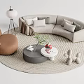 Curved Gray Sofa with Pillows and Two Coffee Tables on Woven Rug and Accent Chair