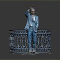 Man in blue suit waving hand behind blue iron railing with intricate floral design