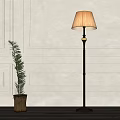 Stylish Floor Lamp With Lampshade And Metal Stand By Gray Paneled Wall With Potted Plant
