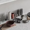 Stylish Kitchenware Collection with Marble Bowl Wooden Board Glass Bottles Metal Canisters on Light Countertop