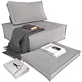 Gray Upholstered Single Sofa With Cozy Blanket And Stacked Books Design