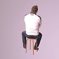 A Man Sitting on Wooden Stool with Crossed Arms in White Jacket and Blue Jeans