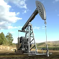 Industrial Oil Pump for Oil Extraction in Open Field With Mountainous Landscape and Blue Sky