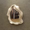 Irregular Curved Edge Mirror With Metallic Finish Reflecting Bedroom Interior On Gray Wall