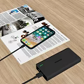 Smartphone Charging With Portable Power Bank On Magazine And Wooden Desk