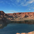 Scenic Red Rock Mountains and Blue Lake with Clear Sky and Fluffy Clouds