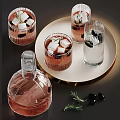 Transparent Glass Cups With Ice Cubes And Rosemary On Gold Tray Near Rose Liquid Decanter