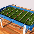 Blue Foosball Table With Green Grass Surface And Player Rods On Wooden Floor
