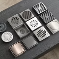 Various Metal Floor Drain Covers With Unique Designs On Dark Table 3d model