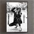 Fashionable Woman in Black Leather Crouching Taking Photo Street Portrait with Streetlights and Trees