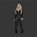 Woman With Blonde Hair In Black Tight Jumpsuit And Black Boots Standing Against Gray Background