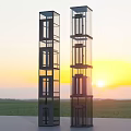 Tall Glass Elevators In Green Field With Beautiful Sunset Sky Background
