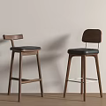 Two Modern Bar Stools With Wooden Frame And Black Seat Against Beige Wall On Wood Floor