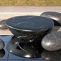 Black Marble Round Outdoor Table With Pebble Shaped Stools On Wooden Deck And Reflective Tiles