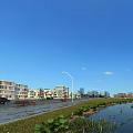Modern Industrial Factory Building Featuring Pond Street Lights Greenery And City Skyline Under Clear Sky