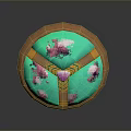 Decorative Circular Artifact With Brown Outer Frame Green Base Pink Floral Patterns And Central Pink Gemstone