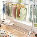 Metal Clothes Rack Hanging Various Colored Clothes With Storage Box On Wooden Bedroom Floor