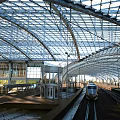 Contemporary Railway Station Featuring Glass Roof Steel Structure And Train On Platform