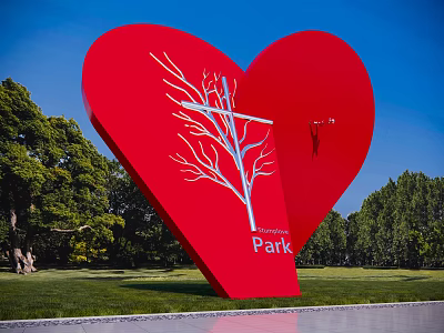 Red Heart Shaped Landscape Sculpture with White Tree Design in Park Green Trees Blue Sky 3d model