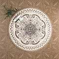 Round Rug with Intricate Pattern Beige and Brown on Geometric Wood Floor with Potted Plant