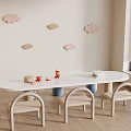 Wooden Kids Chairs In Children's Play Area With White Oval Table Cloud Wall Decorations And Toys