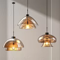 Three Transparent And Brown Glass Pendant Lights Hanging On White Wall With Light Glow