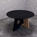 Black Round Dining Table With Geometric Black And Wooden Base On Gray Marble Floor
