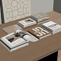 Open Book And Stacked Magazines On Wooden Table With Geometric Wall Art