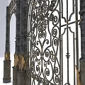 Wrought Iron Arched Gate And Decorative Door With Intricate Patterns And Pillars