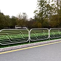 White Metal Roadside Railing With Green Plants And Trees Along Grassland