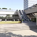 Outdoor Escalator In Modern Commercial Building With Glass Facade Steps And Greenery