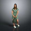 A Woman In Green Floral Dress Holding Green Bag With White Shoes Against Gray Background