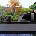 Rockery Stones In Garden Courtyard With Green Plants Trees Pool Water Reflections And Wooden Roof