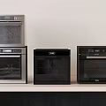Modern Kitchen Appliances In Various Colors Displayed On Countertop With White Wall