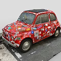 Small Red Car Covered with Various Stickers All Over the Body