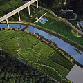 Scenic Garden Landscape With Green Agricultural Fields Winding River Bridge And Lush Vegetation