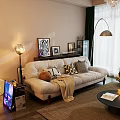 Large Beige Sofa With Throw Pillows Blanket And Decorative Paintings In Cozy Living Room