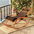 Wicker Rocking Armchair With Wooden Frame Striped Cushion On Balcony With Flowers
