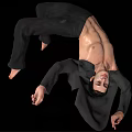 Man In Dynamic Acrobatic Pose Shirtless With Black Pants And Jacket Against Black Background