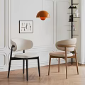 Modern Beige Upholstered Chairs In White Paneled Room With Artwork And Orange Pendant Light