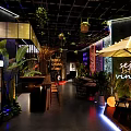Modern Bar Interior With Green Plants Neon Signs And Cozy Seating